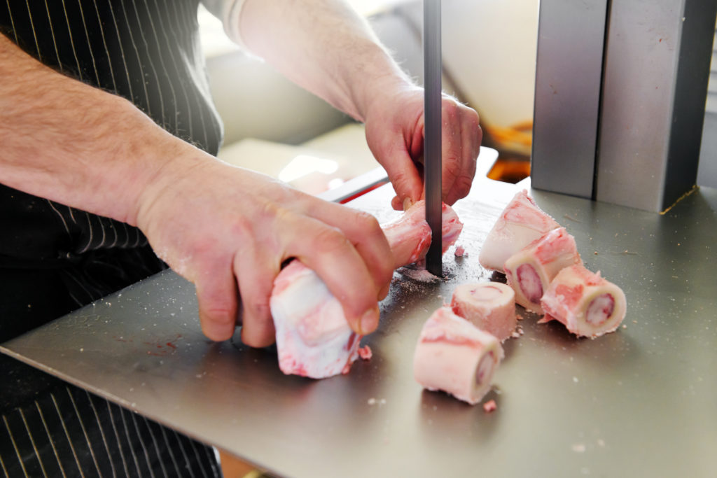 Sawing marrow bones from a calf femur